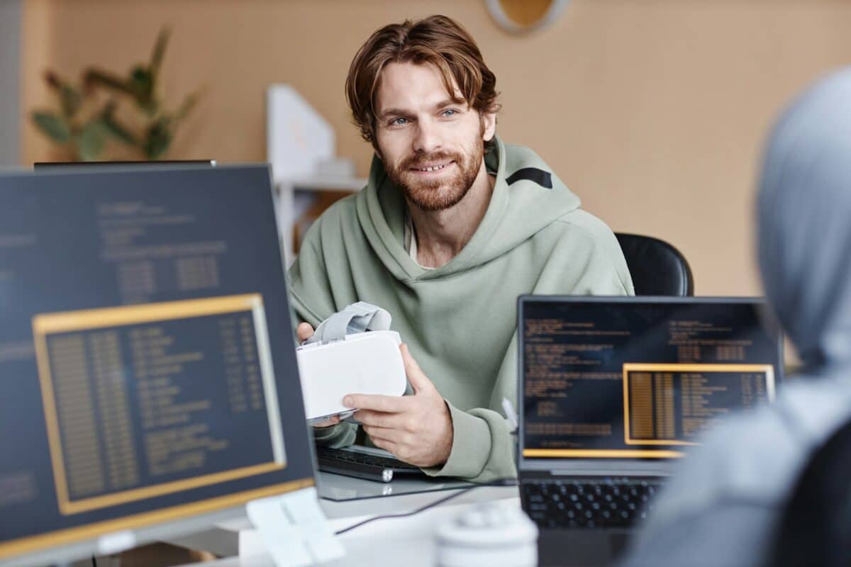 Smiling IT Developer Talking To Colleague in Office